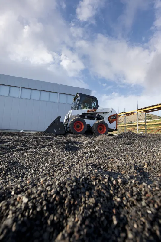 Bobcat S510 with combination bucket in a car park