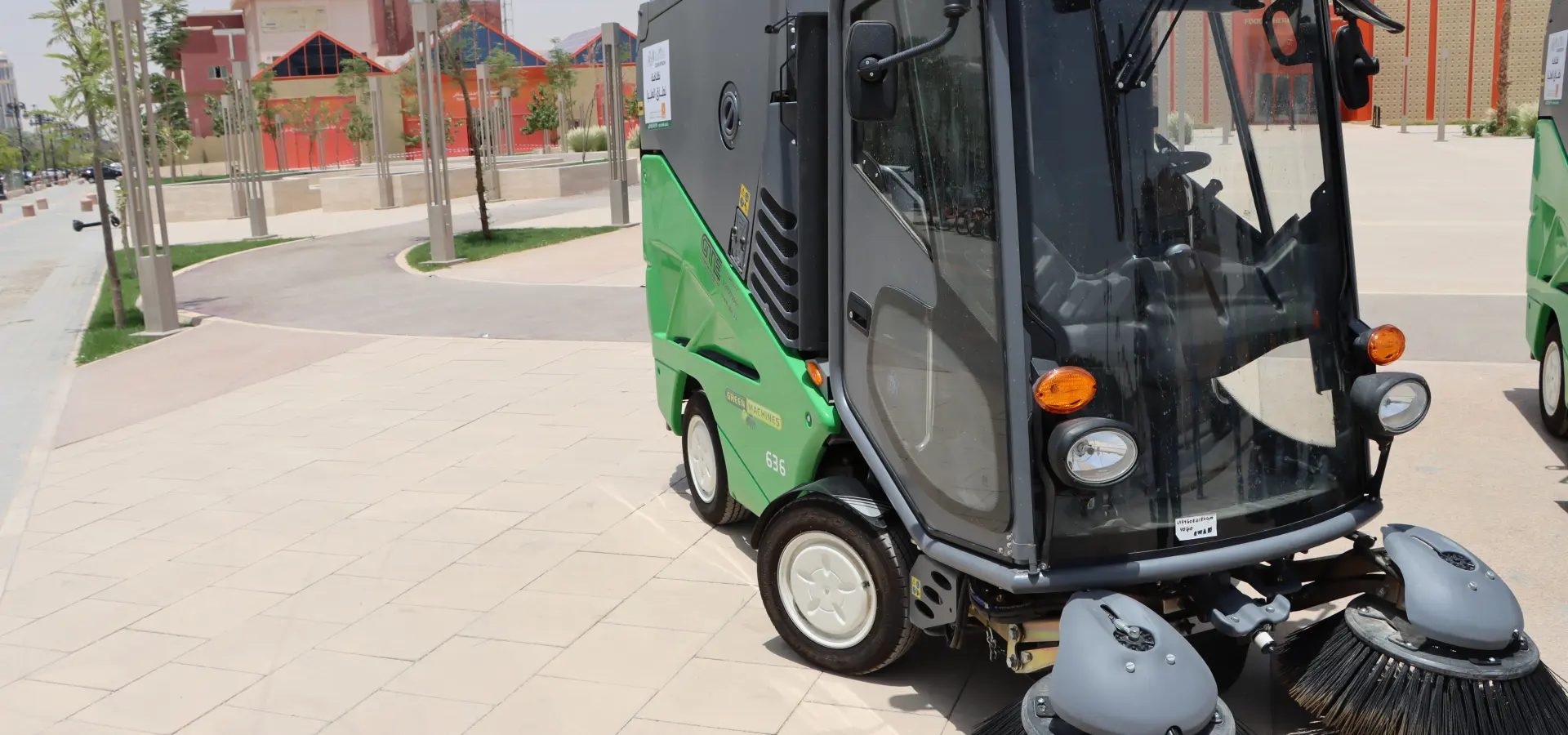 Green Machines compact street sweeper cleaning a paved plaza